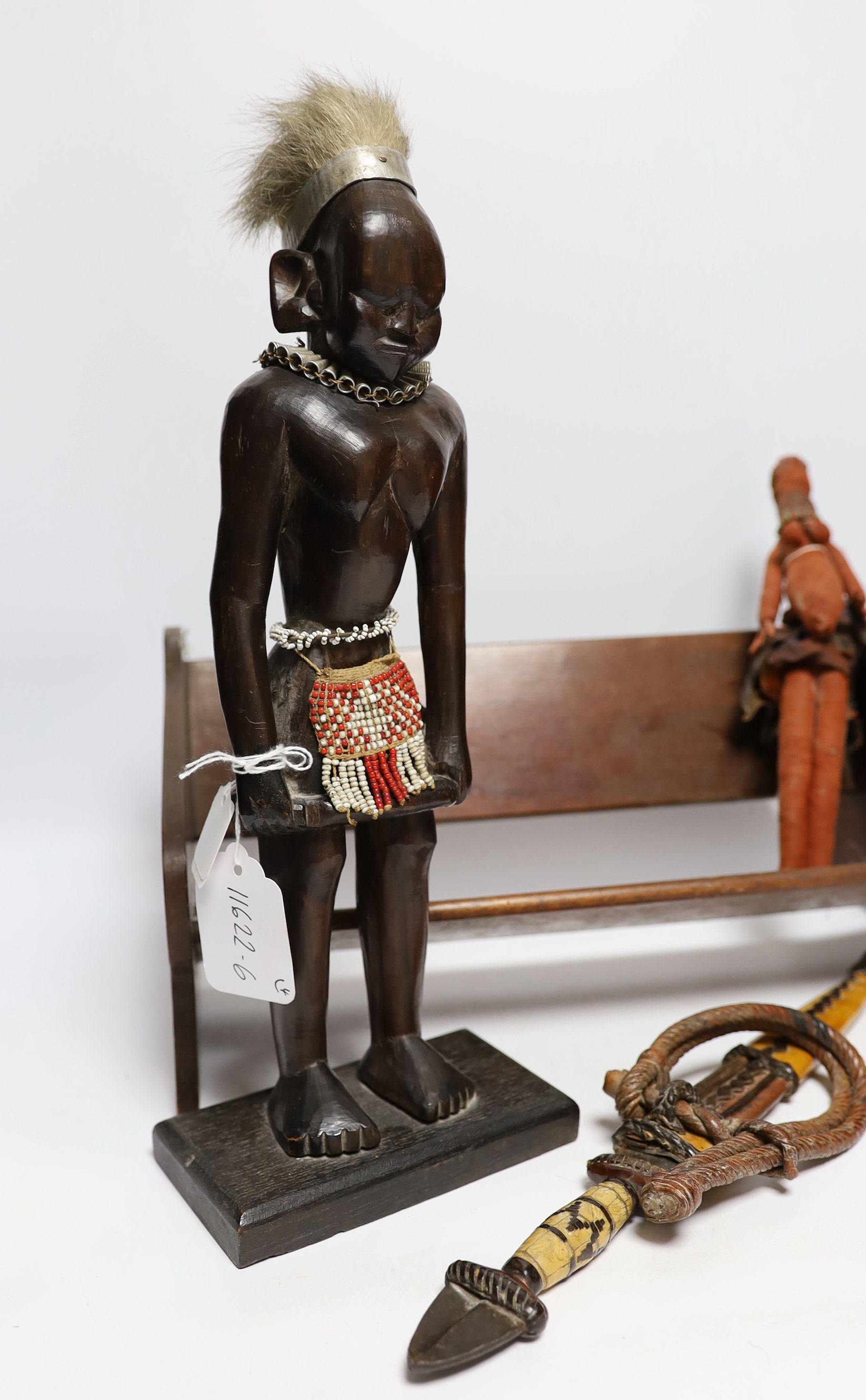 A collection of tribal items including fabric doll, African carved wood figure and dagger, largest 35cm wide